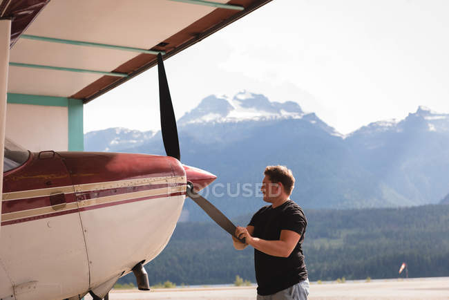 Mechanic checking aircraft propeller at aerospace hangar — Stock Photo