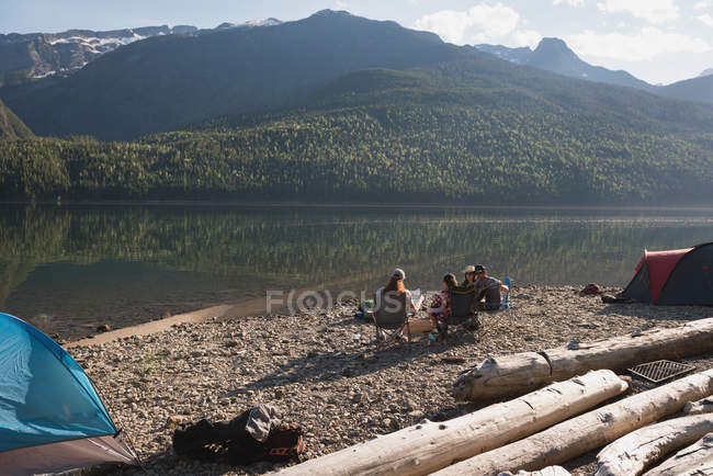 Group of hikers camping near riverside in mountains — Stock Photo