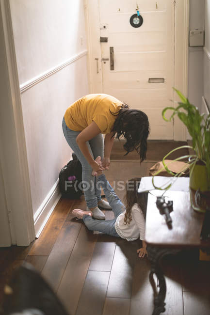 Mother helping her daughter for wearing shoes at home — Stock Photo