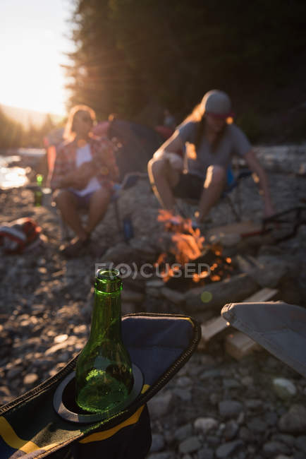Close-up de garrafa de cerveja em uma cadeira de acampamento — Fotografia de Stock