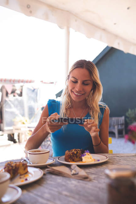 Bella donna scattare foto dal telefono cellulare in caffè all'aperto — Foto stock