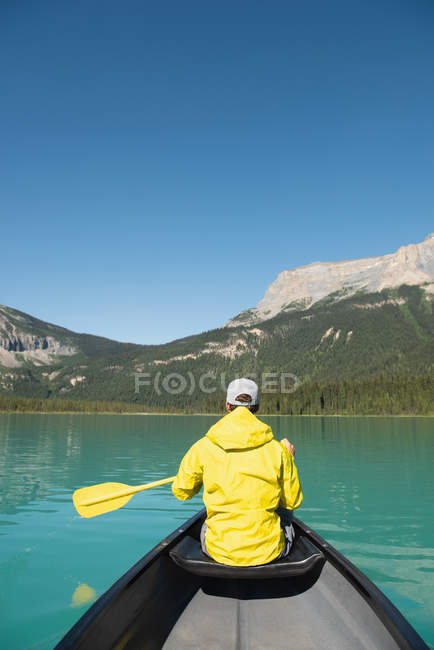 Rear view of man boating in river in mountains — Stock Photo