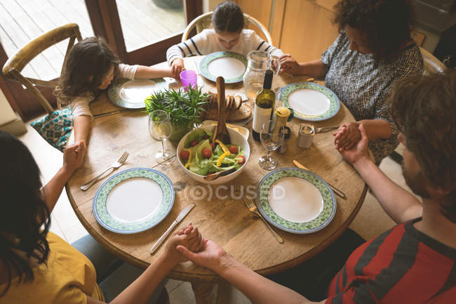 Familie betet vor dem Essen zu Hause — Stockfoto