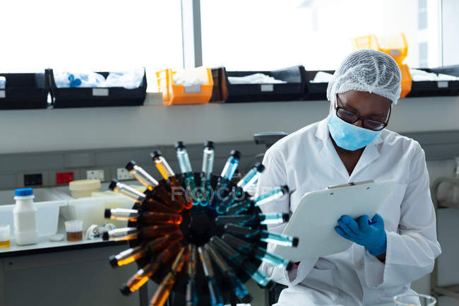 Жіночий вчений пише на кишені в лабораторії — стокове фото
