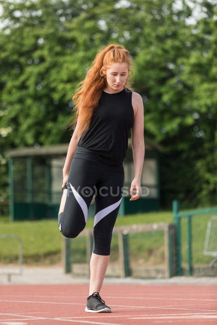 Молодая спортсменка занимается спортом на беговой дорожке — стоковое фото
