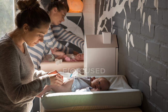 Mother changing diaper of baby at home — Stock Photo