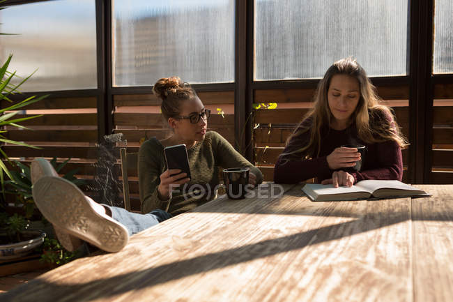 Lesbian couple discussing over book on table at home — Stock Photo