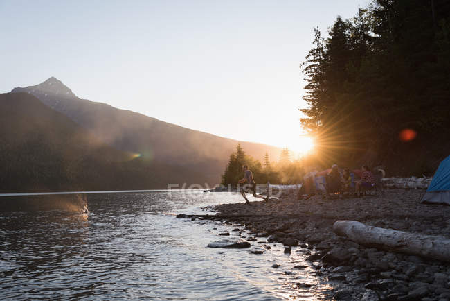 Group of friends camping near riverside in mountains — Stock Photo