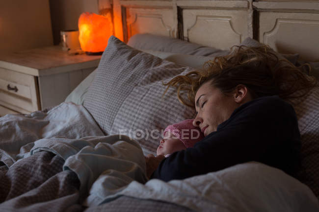 Madre con bambino rilassante sul letto a casa — Foto stock