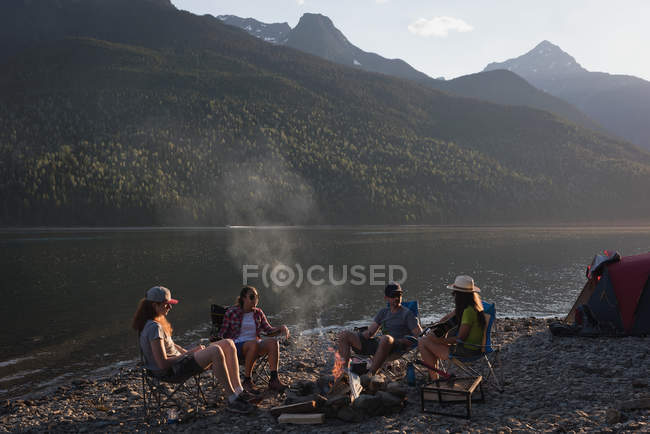 Gruppe von Freunden zeltet an einem sonnigen Tag in der Nähe des Flusses — Stockfoto