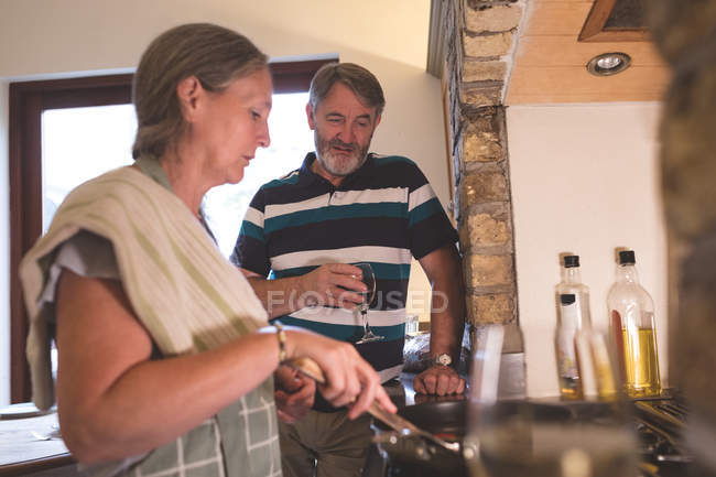 Senior couple cooking food in kitchen at home — Stock Photo