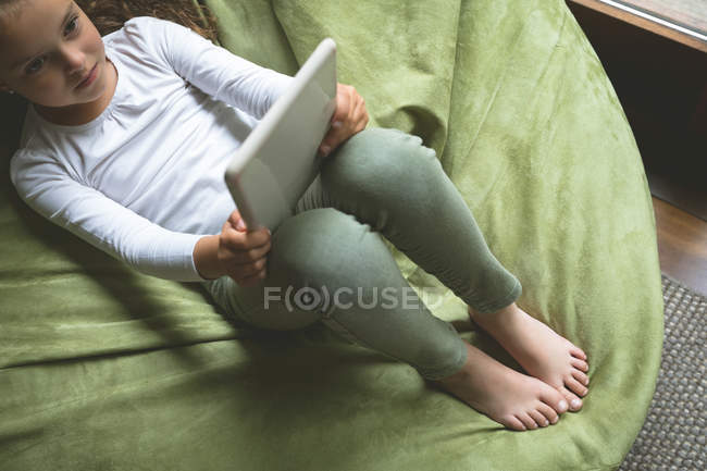 Overhead de chica usando tableta digital en la sala de estar en casa - foto de stock