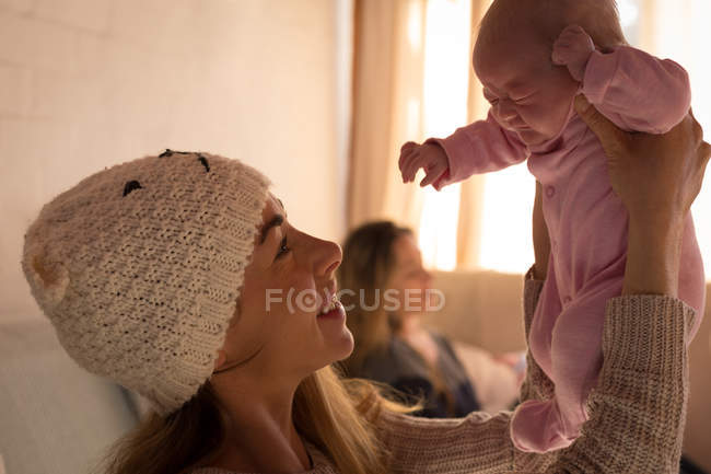 Mutter spielt mit Baby auf Sofa zu Hause — Stockfoto