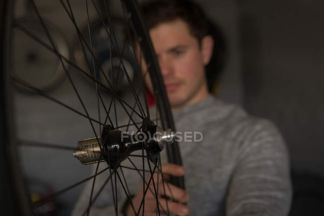 Young disabled man repairing wheelchair at workshop — Stock Photo