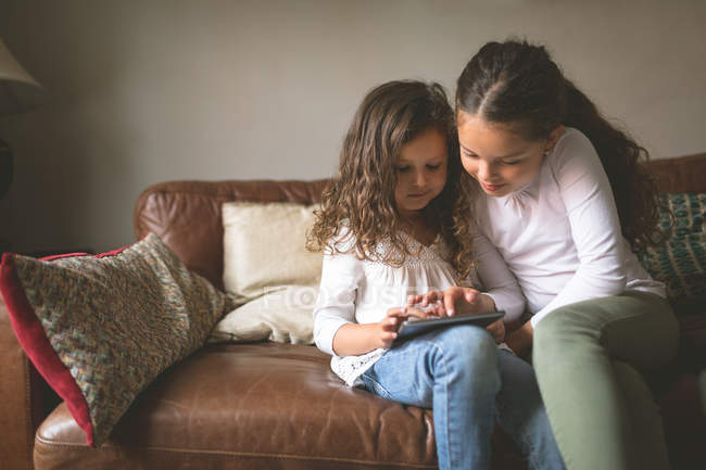 Mädchen nutzen digitales Tablet zu Hause auf dem Sofa — Stockfoto