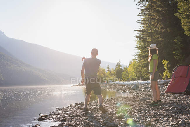 Paar vergnügt sich in Ufernähe in den Bergen — Stockfoto