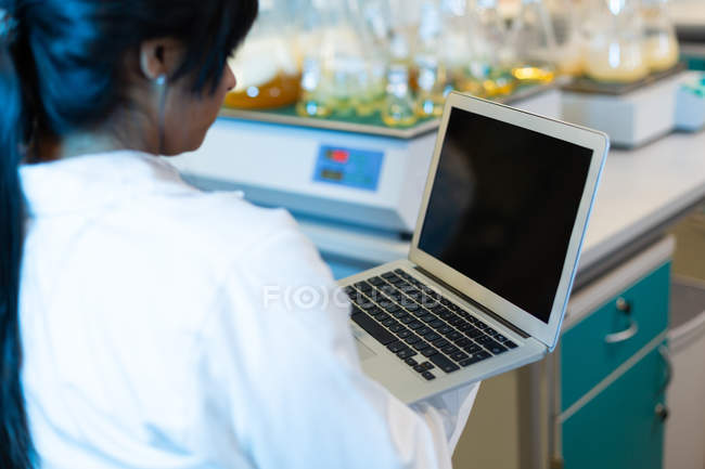 Female scientist using laptop in laboratory — Stock Photo