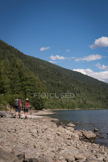 Vue arrière du couple marchant près de la rivière — Photo de stock