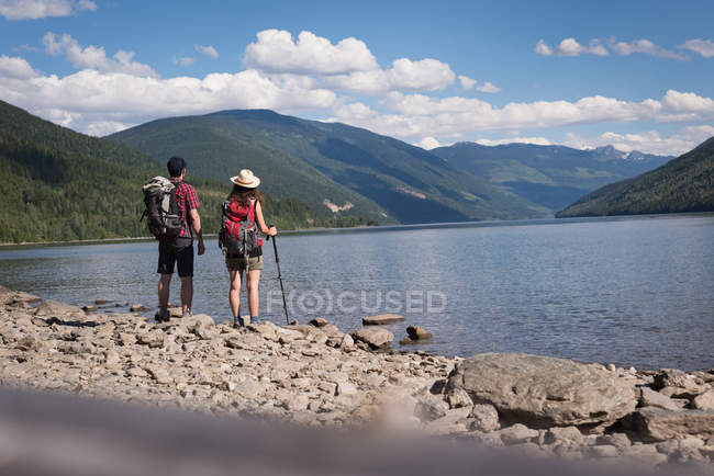 Visão traseira do casal em pé perto da ribeira — Fotografia de Stock
