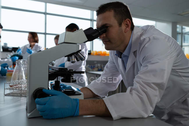 Науковець у лабораторії користується мікроскопом. — стокове фото