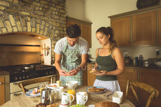 Пара готує сніданок на обідньому столі вдома — стокове фото