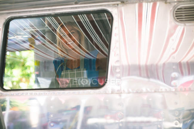 Щаслива жіноча офіціантка працює в харчовій вантажівці — стокове фото