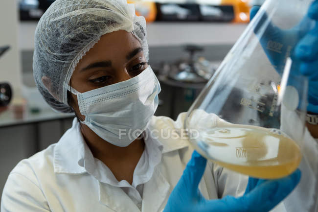 Primer plano de la mujer científica experimentando en laboratorio - foto de stock