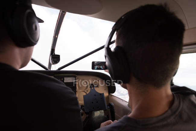 Piloten machen Selfie mit Handy im Flugzeug-Cockpit — Stockfoto