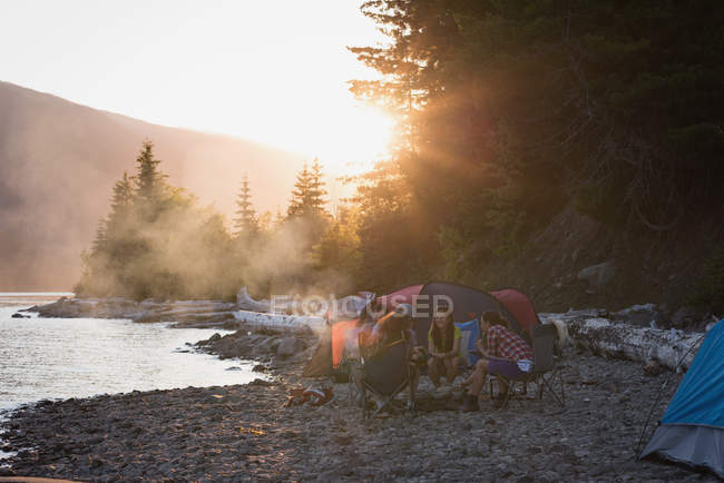 Група друзів у кемпінгу біля берега річки в горах — стокове фото