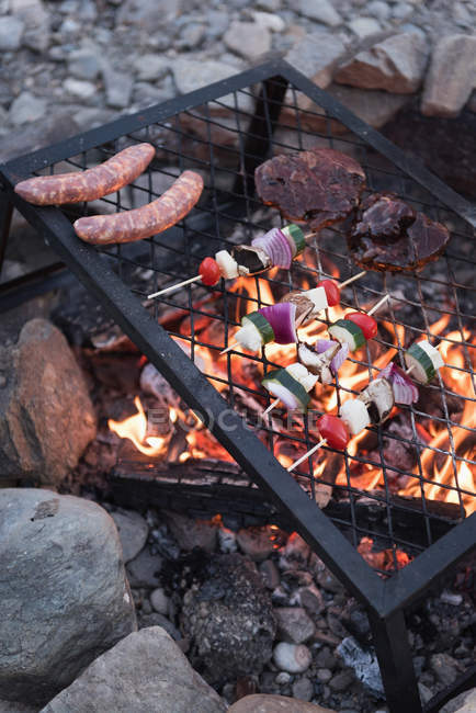 Gros plan sur la nourriture gardée sur un barbecue au camping — Photo de stock