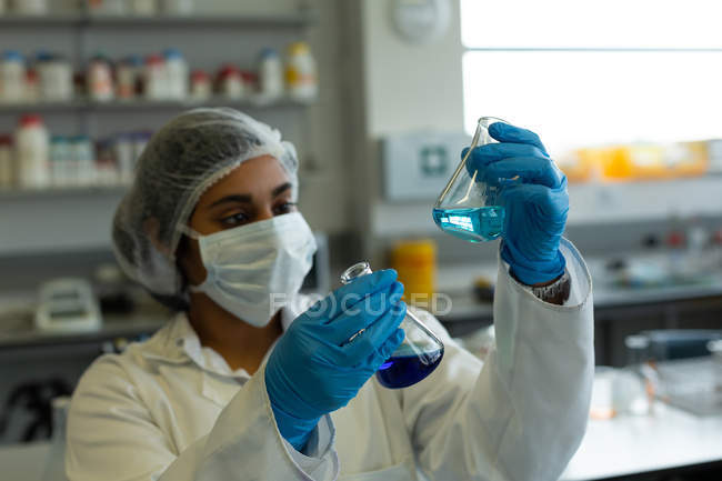 Científico masculino atento experimentando en laboratorio - foto de stock