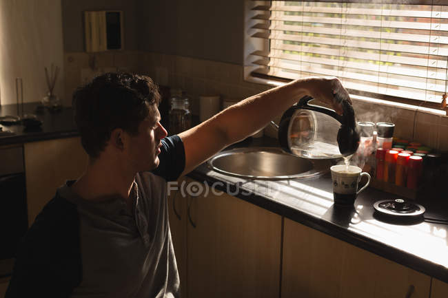 Homem com deficiência preparando café na cozinha em casa — Fotografia de Stock