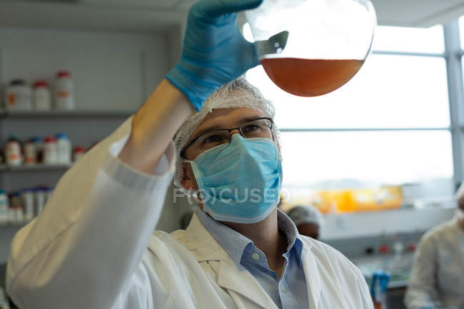 Внимательный ученый-мужчина экспериментирует в лаборатории — стоковое фото
