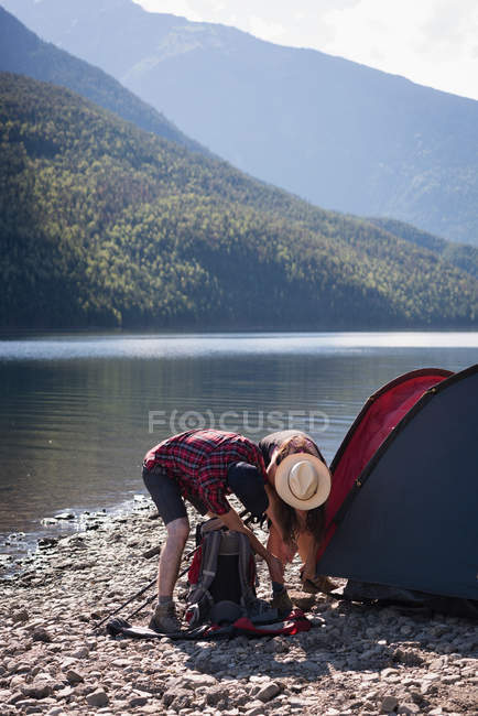 Paar baut Zelt an sonnigem Tag auf — Stockfoto