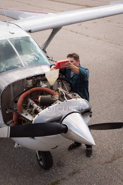 Hochwinkelaufnahme des Ingenieurs, der Öl in Flugzeugtriebwerk füllt — Stockfoto