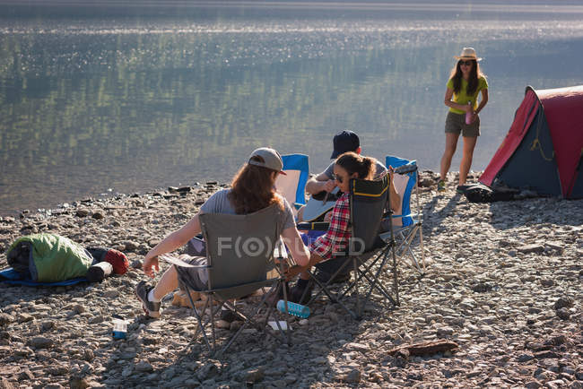 Group of hikers camping near riverside at countryside — Stock Photo