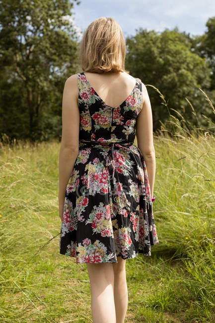 Задумчивая женщина, стоящая в поле — стоковое фото