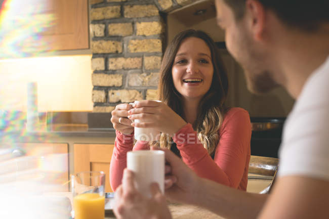 Coppia che interagisce tra loro mentre prende un caffè a casa — Foto stock