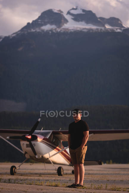Pilot steht an einem sonnigen Tag in Flugzeugnähe — Stockfoto