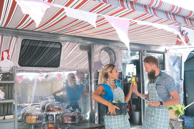 Couple interacting with each other near food truck — Stock Photo