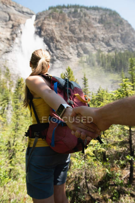 Пара тримає руки в горах в сонячний день — стокове фото