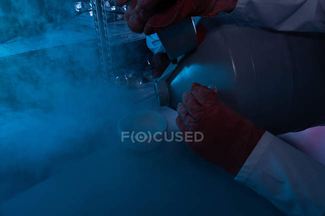 Wissenschaftler gießt im Labor Flüssigkeit in eine Schüssel — Stockfoto