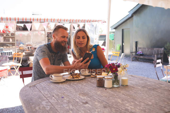 Romantic couple taking selfie on mobile phone in outdoor cafe — Stock Photo