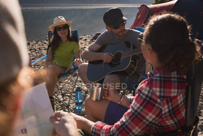 Группа друзей кемпинга возле реки в солнечный день — стоковое фото