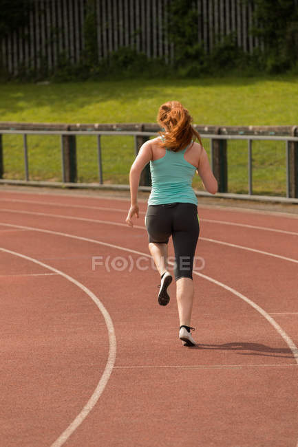 Вид ззаду жіночого спортивного бігу на спортивній трасі — стокове фото