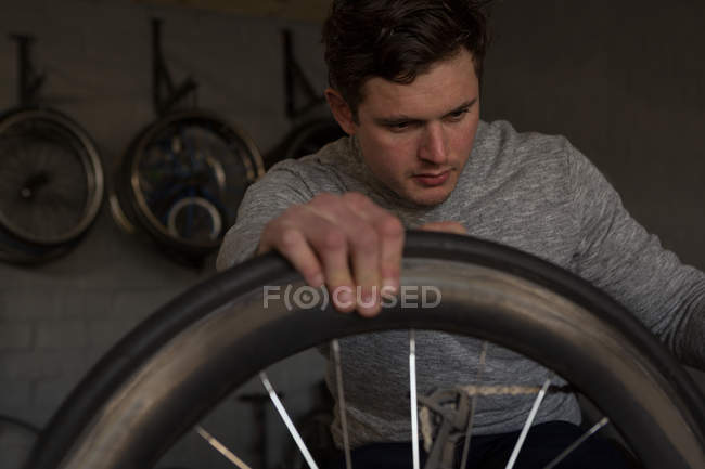 Молодой инвалид ремонтирует инвалидное кресло в мастерской — стоковое фото