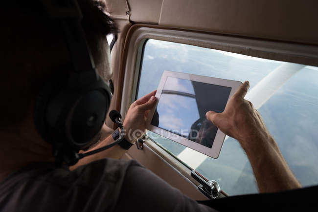 Piloto tira fotos com mesa digital enquanto voa no cockpit da aeronave — Fotografia de Stock