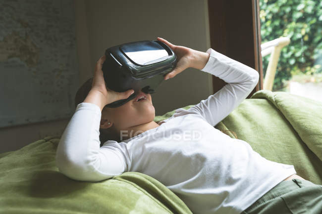 Дівчина за допомогою віртуальної реальності гарнітуру у вітальні на дому — стокове фото