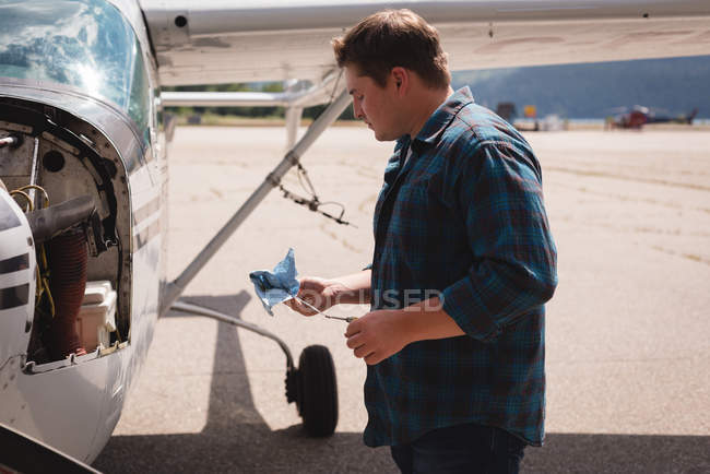 Side view of engineer servicing aircraft engine near hangar — Stock Photo