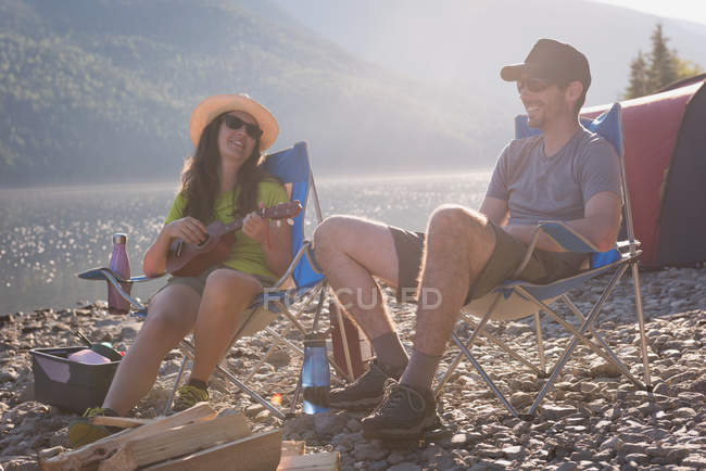 Couple camping au bord de la rivière en montagne — Photo de stock